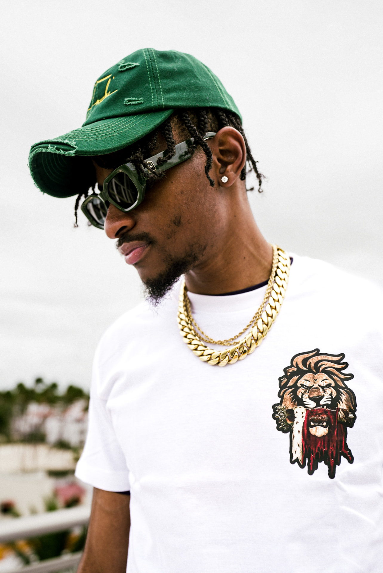 White heavyweight tee with the crowned LDI lion printed on the chest, worn with a green signature cap